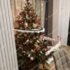 Künstlicher Weihnachtsbaum 3D Skandinavische Fichte 180cm ist mit weißem und rotem Schmuck und einer Weihnachtseisenbahn geschmückt
