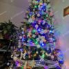 Künstlicher Weihnachtsbaum Nordische Fichte 250cm geschmückt mit weißem Weihnachtsschmuck und farbiger Beleuchtung