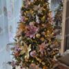 Künstlicher Weihnachtsbaum, grün, verziert mit weißen und rosafarbenen Ornamenten, im Wohnzimmer