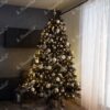 Künstlicher Weihnachtsbaum, breit und hoch grün, verziert mit weißen und goldenen Ornamenten, im Wohnzimmer