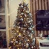 Eisgrüner künstlicher Weihnachtsbaum, verziert mit weißen und goldenen Dekorationen, im Wohnzimmer