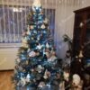 Eisgrüner künstlicher Weihnachtsbaum, verziert mit weißen und goldenen Ornamenten, im Wohnzimmer