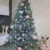 Eisgrüner künstlicher Weihnachtsbaum, geschmückt mit silberrosa Verzierungen, im Wohnzimmer