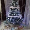 Künstlicher Weihnachtsbaum groß und massiv, verziert mit weißen Ornamenten im Wohnzimmer