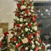 Künstlicher grüner Weihnachtsbaum mit roten und goldenen Ornamenten im Wohnzimmer
