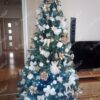 Künstlicher grüner Weihnachtsbaum mit goldenen und weißen Ornamenten im Wohnzimmer
