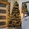 Künstlicher grüner Weihnachtsbaum mit goldenen Ornamenten im Wohnzimmer