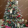 Künstlicher Weihnachtsbaum mit schneebedeckten Enden und rotgoldenen Verzierungen im Wohnzimmer