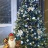 Künstlicher Weihnachtsbaum mit weißen Dekorationen im Wohnzimmer