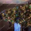 Grüner künstlicher Weihnachtsbaum mit goldenem Weihnachtsschmuck im Wohnzimmer