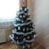 Ein künstlicher Weihnachtsbaum, geschmückt mit weißem Weihnachtsschmuck, im Wohnzimmer,