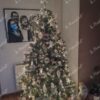 Grüner künstlicher Weihnachtsbaum, geschmückt mit weißem Weihnachtsschmuck, mit weißer Beleuchtung, im Wohnzimmer,