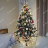 Ein kleiner grüner künstlicher Weihnachtsbaum mit versilberten Zweigenden und Eiskristallen, geschmückt mit weißem und rotem Weihnachtsschmuck, im Wohnzimmer,