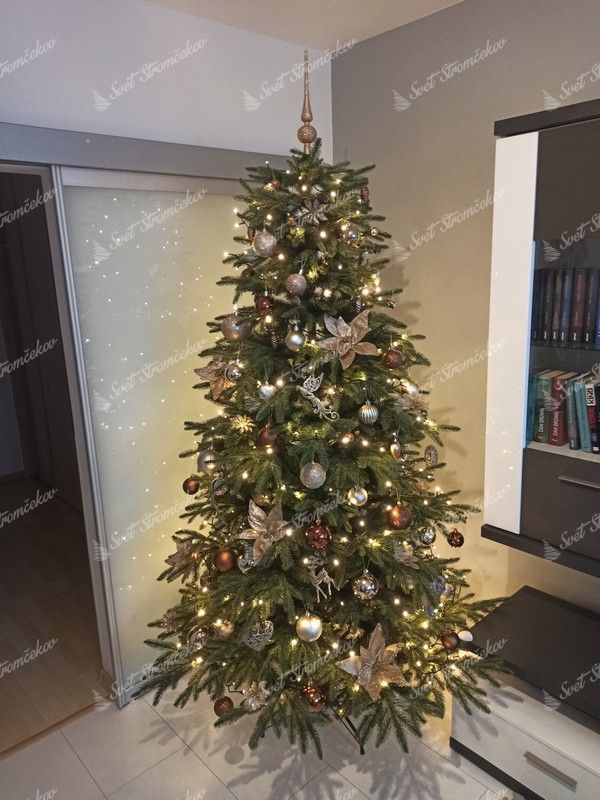 Umelý vianočný stromček so zelenými vetvičkami, ozdobený zlato-medenými ozdobami.
