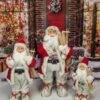 Vianočná dekorácia Santa Claus Červeno-biely, oblečený ma červený kabát s hnedobielou kožušinou a v ruke drží lyže