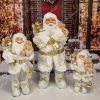 Weihnachtsdekoration Nikolaus Weiß-Gold, trägt einen weiß-goldenen Mantel mit weißem Fell und hält ein Kuscheltier