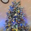 Künstlicher Weihnachtsbaum 3D Königsfichte 120cm, ist mit weißen und goldenen Dekorationen verziert