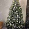 Künstlicher Weihnachtsbaum 3D Robuste Fichte XL 210cm, ist mit weißen und silbernen Verzierungen geschmückt