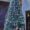 Künstlicher Weihnachtsbaum FULL 3D Tränen-Kiefer 210cm, ist mit weißen und goldenen Dekorationen verziert