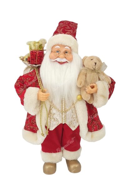 Dekoration Santa Claus Rot-Gold 40cm er trägt einen roten Mantel mit goldenen Verzierungen und einer Kette. er hat goldene Schuhe an. Er hat einen langen weißen Bart, eine Brille und hält ein Kuscheltier in der Hand.