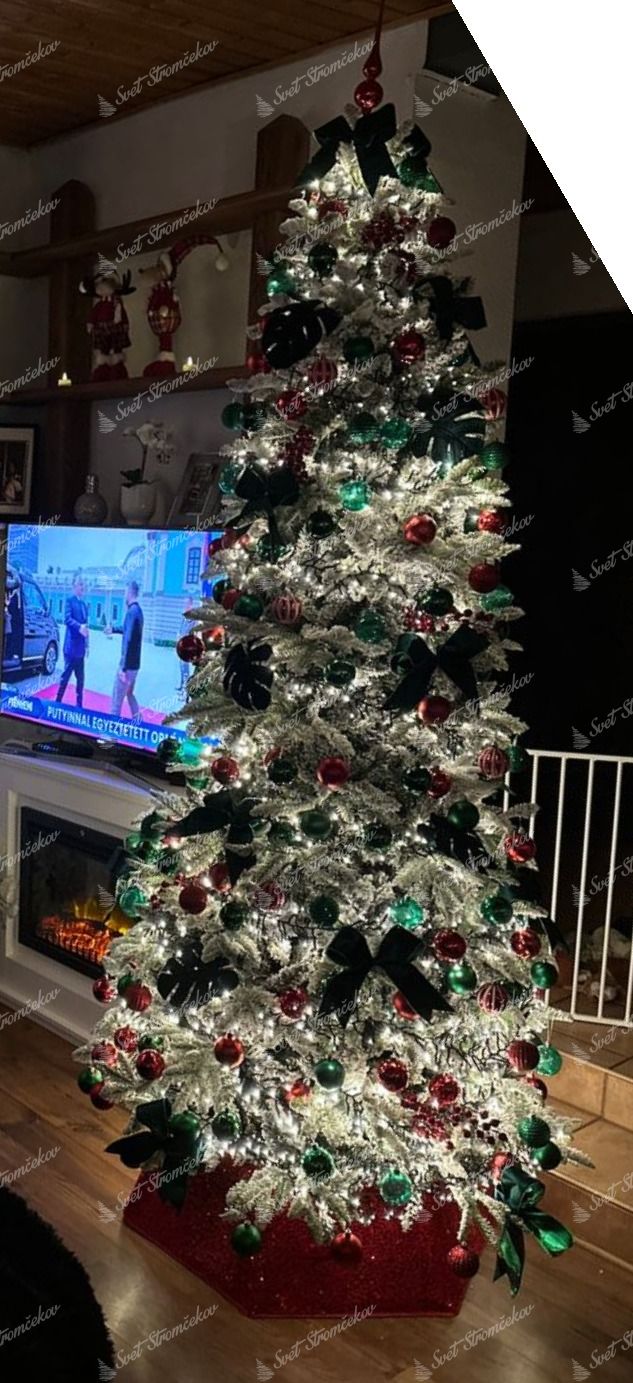 Umelý vianočný stromček 3D Jedľa Pyrenejská Zasnežená 240cm ozdobený červenými a zelenými ozdobami.