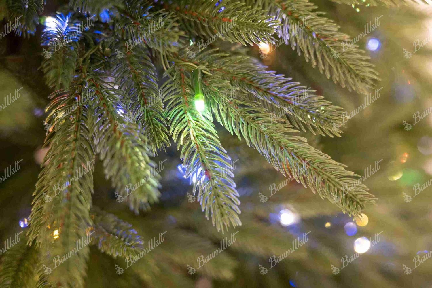 Detail eines Zweigs des künstlichen Weihnachtsbaums FULL 3D Kalifornische Fichte, Der Zweig hat kurze 3D-Fichtennadeln und ein braunes Detail in der Mitte
